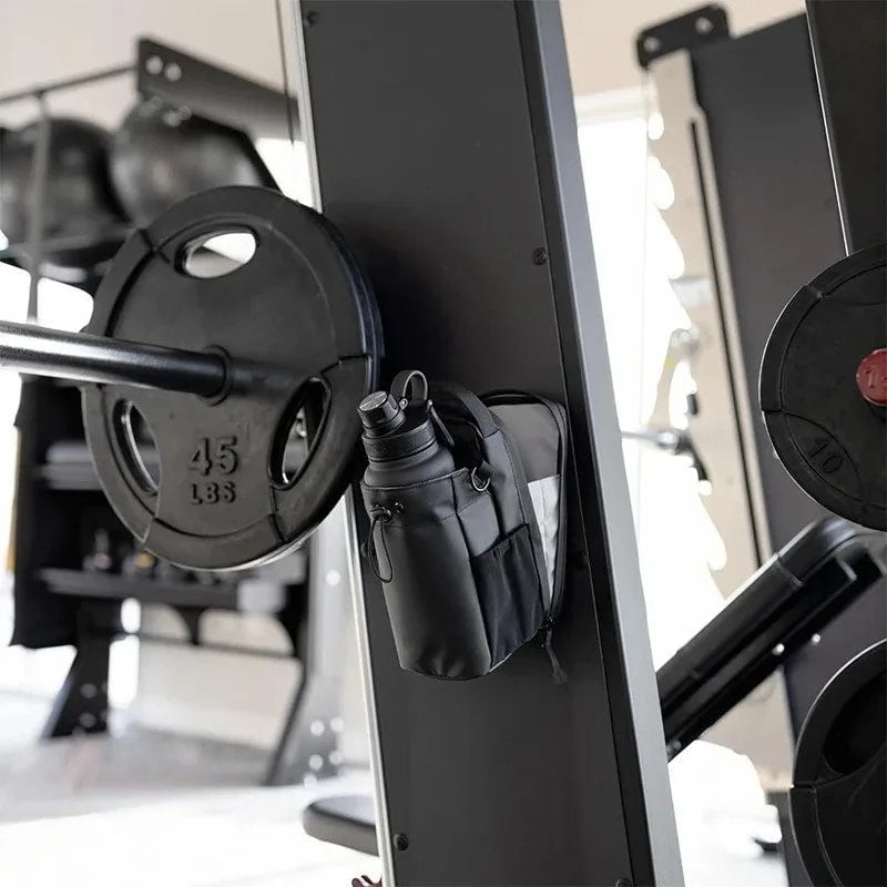CLNCH Magnetic Bottle Bag mounted to power rack next to 45LB plate